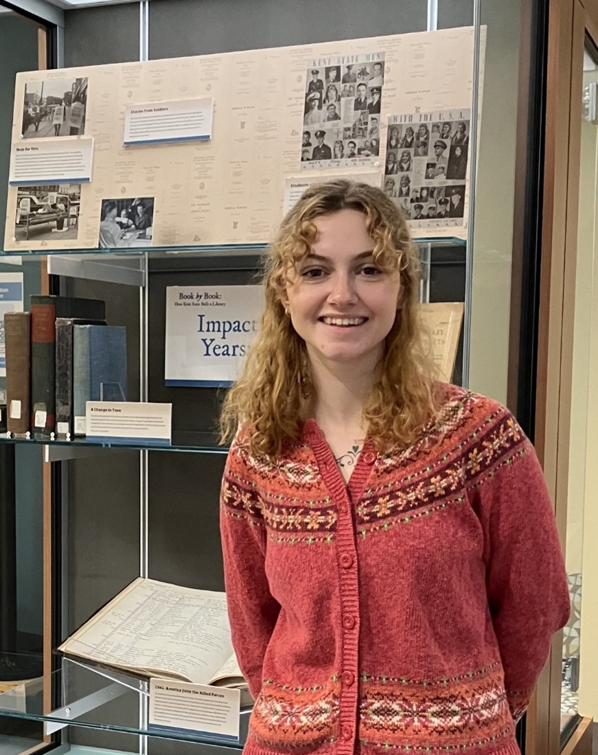 Portrait of Gillian Canacci, Graduate Student Assistant, standing in front of an exhibit she helped to curate.