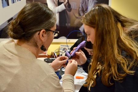 Staff showing student how to use a 3D print pen