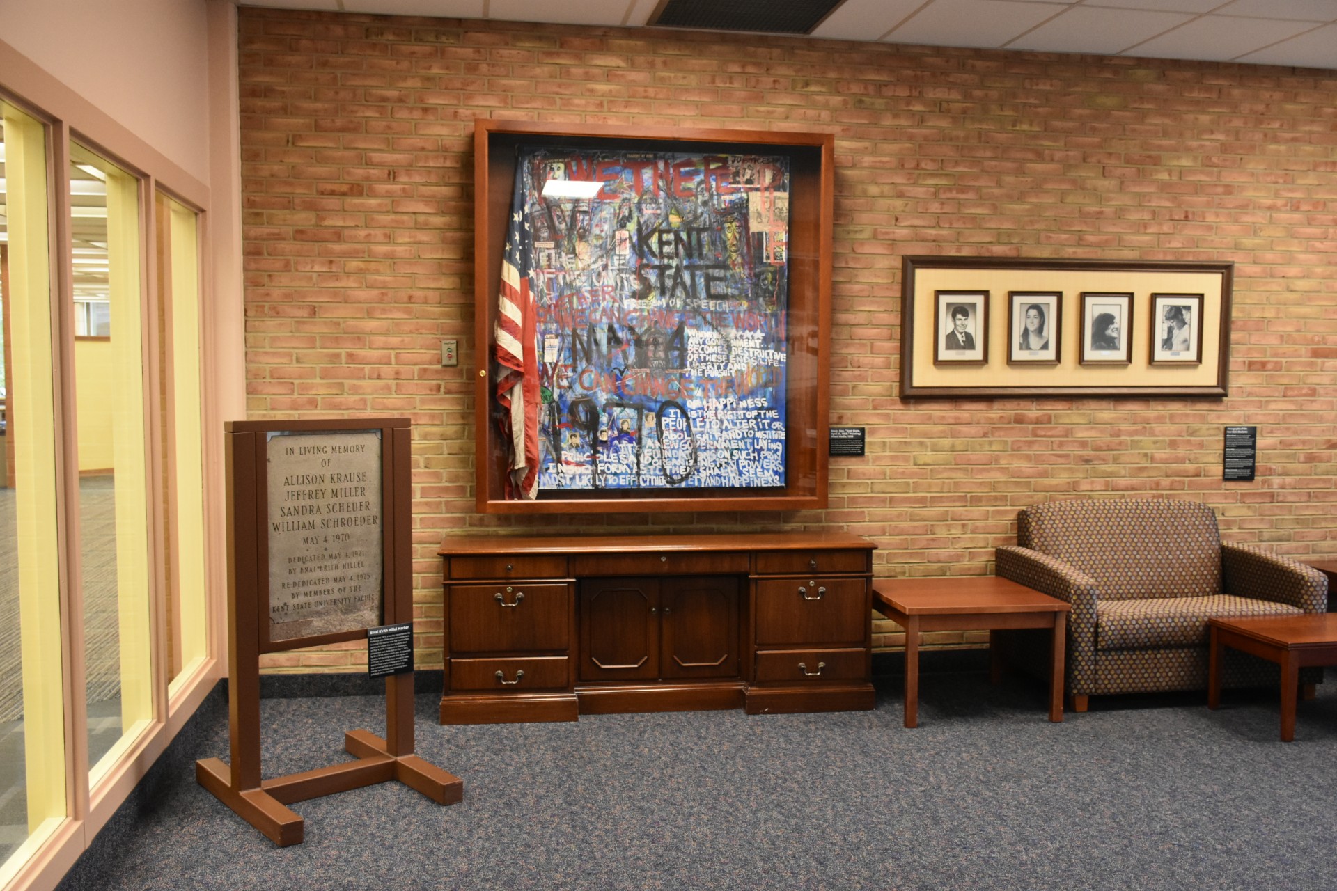 Image of the May 4 Resource Room. A painting, photographs of the four slain students, and a stone plaque are visible.